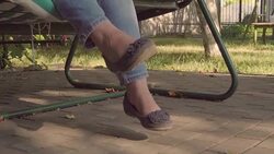 Girl's legs on a swing in the garden Stock Footage