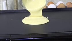 Spooning pancake batter onto a griddle Stock Footage