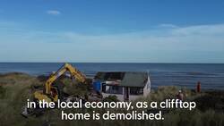 Drone footage of clifftop properties at risk of falling into sea due to coastal erosion News Clip