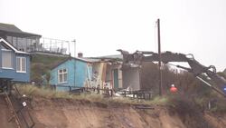 Demolition workers tear down the first of five clifftop homes in the village of Hemsby News Clip