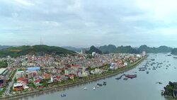 4k Aerial view over city and park with Bai Tho karst mountain Ha long bay. Halong City. Stock Footage