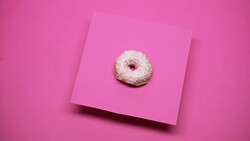 Donut spinning on pink background, junk food, overweight problems, macro shot Stock Footage