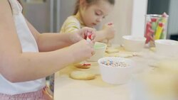 Focused siblings decorating cookie at kitchen Stock Footage