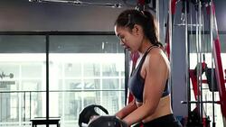 Young fitness woman doing biceps curl with E-Z bar at the gym, fitness training concept Stock Footage