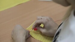 The girl sews by hand a needle and a red thread Stock Footage