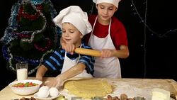 Two kids kneading the dough for xmas cookies together Stock Footage