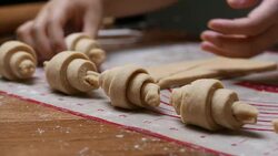 pastry chef hand making croissant on wooden board. Stock Footage