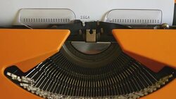 High and side angle footage of a person writing ISLAMOPHOBIA on a typewriter Stock Footage