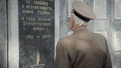 An elderly gray-haired veteran of the great Patriotic war and world war II in uniform with many badges and orders stands near the mass grave. The grandfather remembers horrors of military operations, destruction and death of people Stock Footage