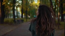 Amazing girl with curly hairstyle in coat walk in autumn alley and smiling Stock Footage