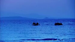 WIDE ANGLE OF SOLDIERS ON TWO SMALL RAFTS OR BOATS PADDLING TO SHORE. OCEAN OR OTHER LARGE BODY OF WATER. MOUNTAINS IN BACKGROUND. SOLDIERS REACH SANDY BEACH AND RUN WITH THEIR MACHINE GUNS. COULD BE DAWN. ARMY. Stock Footage