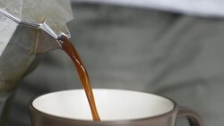 Hot coffee is poured from moka coffee maker Stock Footage
