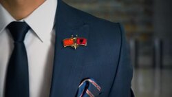 Businessman Walking Towards Camera With Friend Country Flags Pin China - Albania Stock Footage