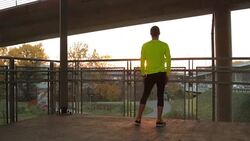 Young man stretching on a fence after jogging / exercising. Stock Footage