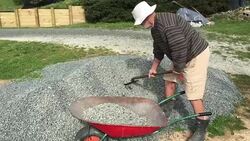 Adult Senior Man Filling a Wheel Barrel with Gravel Stock Footage