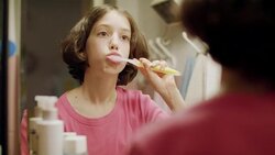 young girl brushing her teeth in front of the mirror Stock Footage