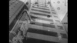 United States, c.1951: A parked car in a garage is unloaded and prepared to be brought down to the lobby for the motorist Stock Footage