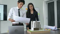 Businessman and businesswoman are working on paper blueprint and building model. Business woman suggest idea to designer. concept of construction, architecture, development and creative. Stock Footage