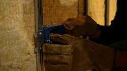 Contractor inspects a uncovered outlet in unfinished basement Stock Footage