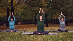 Spititual young women are meditating sitting in lotus position on yoga mats in park and breathing fresh air relaxing after outdoor practice. Meditation and nature concept. Stock Footage
