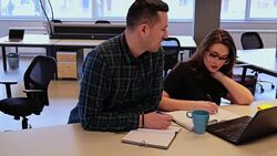 Manager explaining to his female colleague at office desk Stock Footage