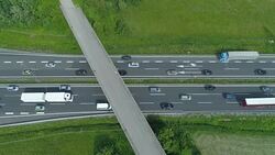 TOP DOWN: Cars and trucks drive through a congestion forming under the overpass. Stock Footage