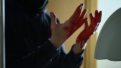 Shocked criminal looking at bloody palms, washing hands in sink after homicide Stock Footage