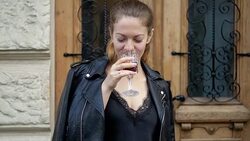 Young woman drinks wine from a crystal glass and enjoys a drink. Leisure of successful people on the road. Stock Footage