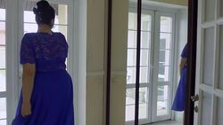 Fat girl in a blue dress in front of a mirror Stock Footage