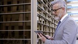 Businessman using digital tablet outside office Stock Footage