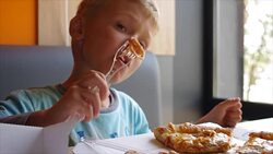 little cute boy eating pizza with appetite Stock Footage