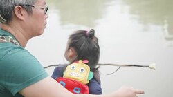 Asian young mother and young father with her adorable two year old girl playing outdoors with love, feeding food to fish and turtle. concept of family love of nature. happy children with the love of parents. Stock Footage