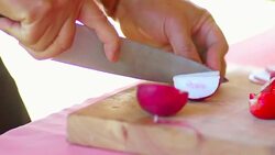 Preparing vegetables in the kitchen slicing radish on a wooden board. Stock Footage