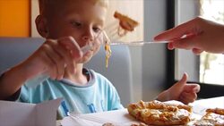 Close up of little cute boy eating pizza. four year old boy eating a slice pizza Stock Footage