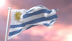 Flag of Uruguay waving at wind in slow at sunset, loop Stock Footage