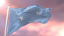 Flag of Micronesia waving at wind at sunset in slow, loop Stock Footage