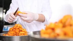 hands pastry chef cutting apricots, prepare the jam in industrial kitchen worktop Stock Footage