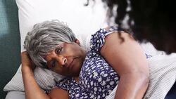 Healthcare worker visiting senior woman suffering with depression lying in bed - shot in slow motion Stock Footage