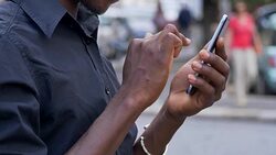 communication,devices,youth. Black man's hands typing on smartphone- outdoor Stock Footage