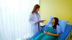 Young Asian female doctor and woman patient lying in bed while discussing and consultation medical examination at hospital room , Healthcare and medical concept, Doctor and patient Stock Footage
