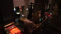 Craftsman working on huge old wooden brocade weaving looms Stock Footage