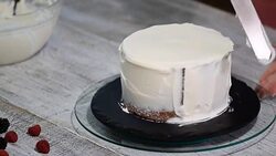 Close up of hands smearing butter cream on chocolate cake by white spatula. Stock Footage