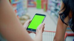 Two young women using smartphone in supermarket,Green screen Stock Footage