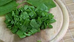 Rotating fresh cut spinach on wooden cutting board Stock Footage