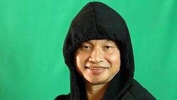 Thai man in hood with green background Stock Footage