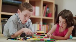 Two kids playing with lego bricks at home Stock Footage