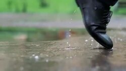 Man in black shoes stepping into the puddle in 4k slow motion 60fps Stock Footage