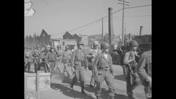 During Korean War after Inchon landing in South Korea, column of US Marines marching down street in Inchon News Clip