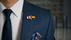 Businessman Walking Towards Camera With Friend Country Flags Pin Japan - Bolivia Stock Footage