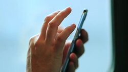 Person hands checking cellphone on a moving train in motion. Hands touching screening scrolling and selecting content while commuting and travelling by train in 4K Stock Footage